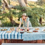 woman setting down food on table outside