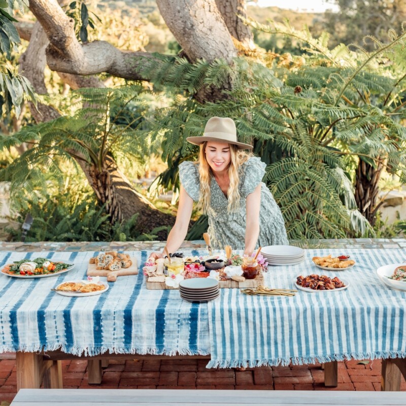 woman setting down food on table outside