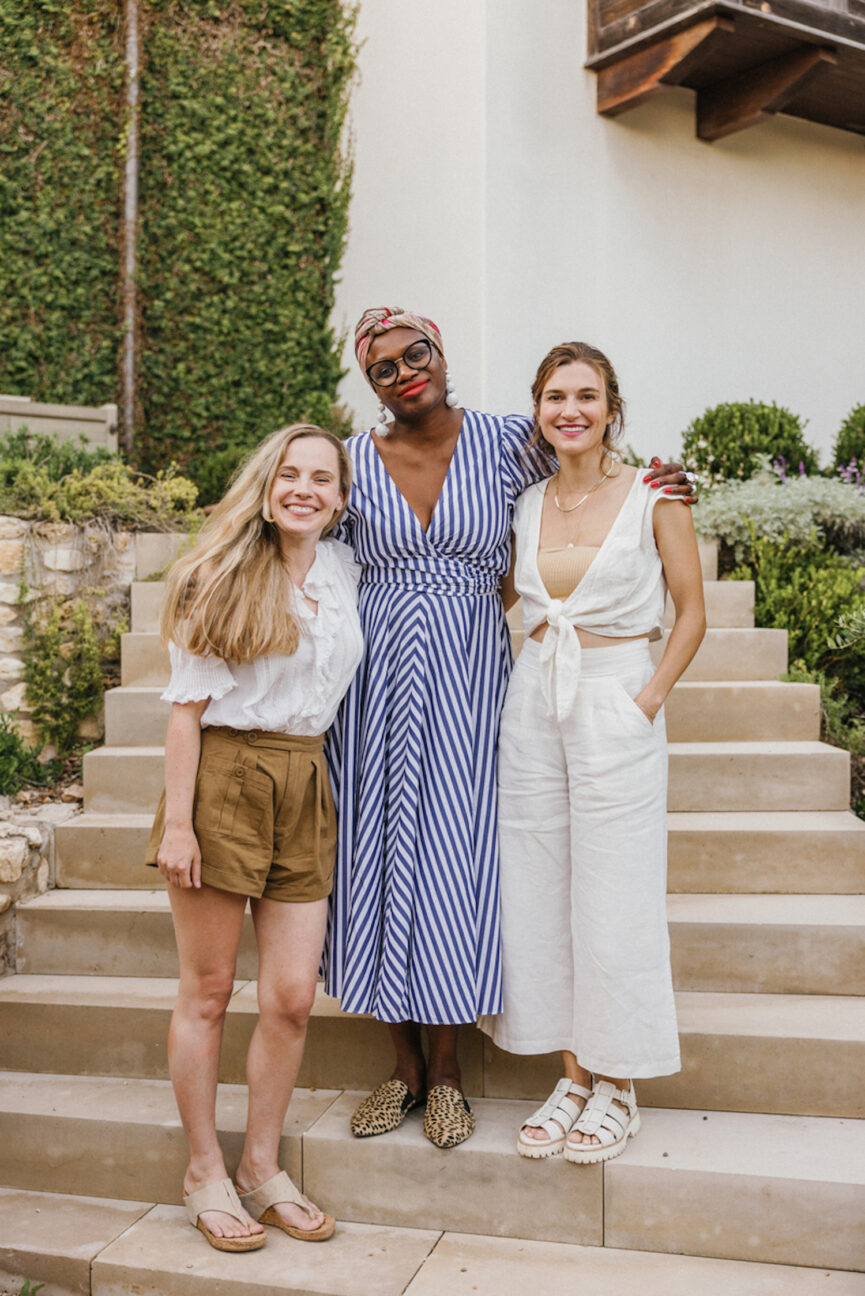 Three friends posing for a picture outside.